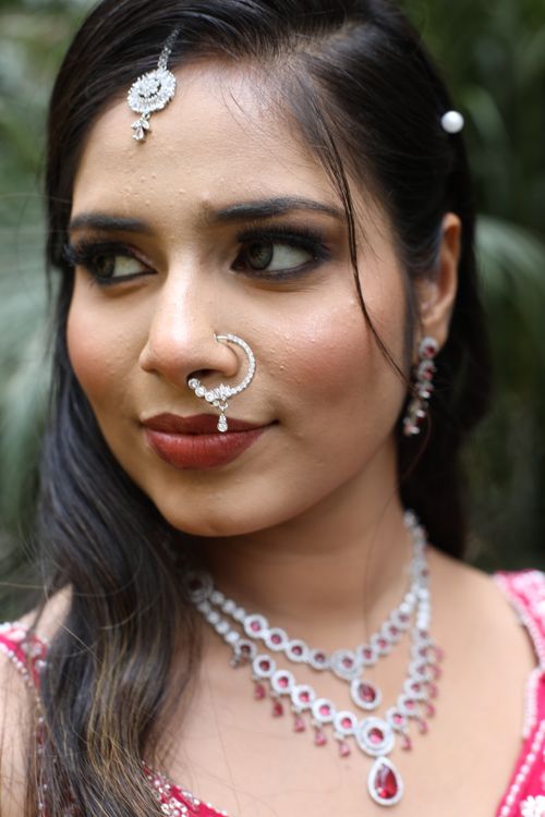 Free Close-up portrait of woman wearing traditional Indian jewelry outdoors. Stock Photo