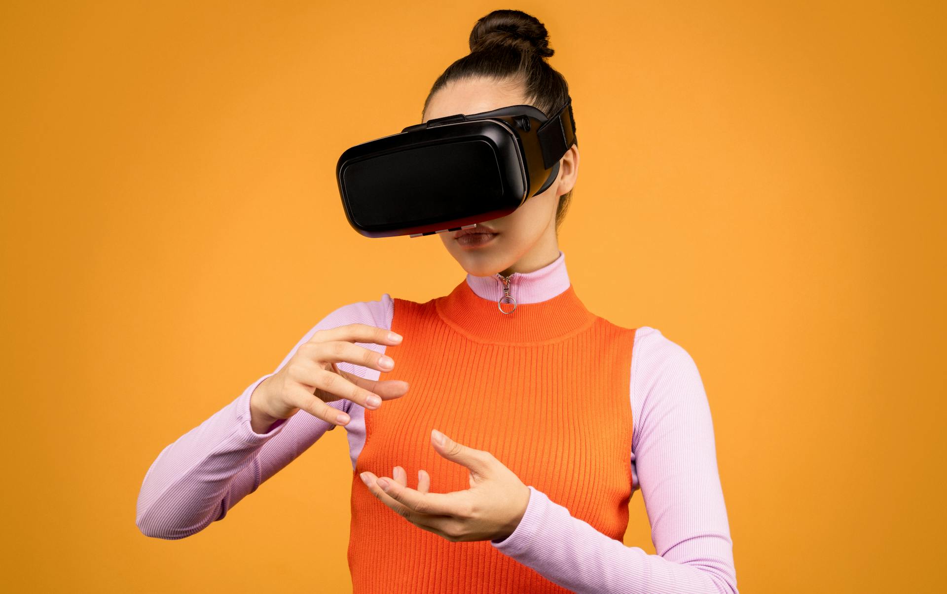 A woman engages with virtual reality using a VR headset, expressing surprise and immersion.