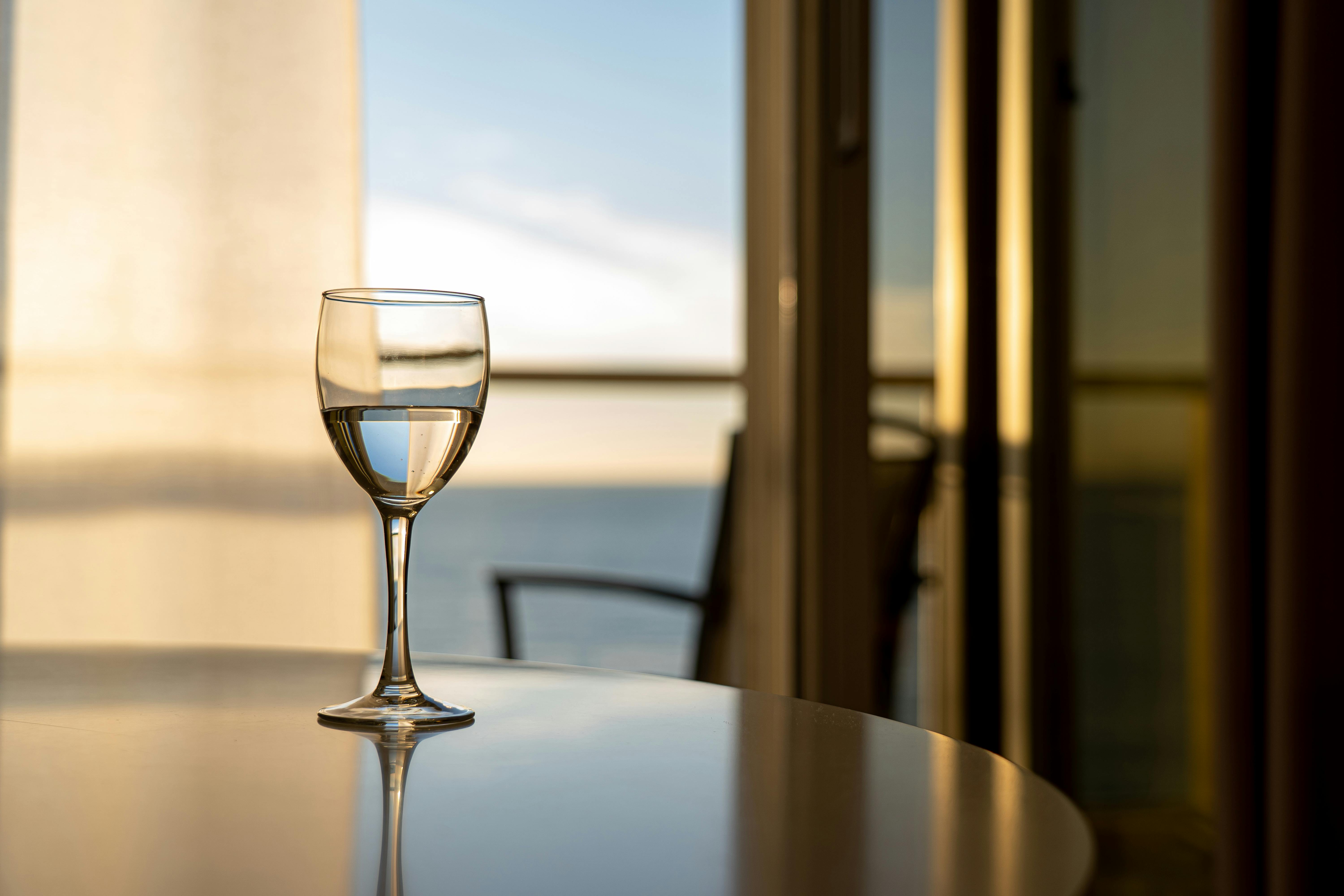 A wine glass on a dining table. | Photo: Pexels