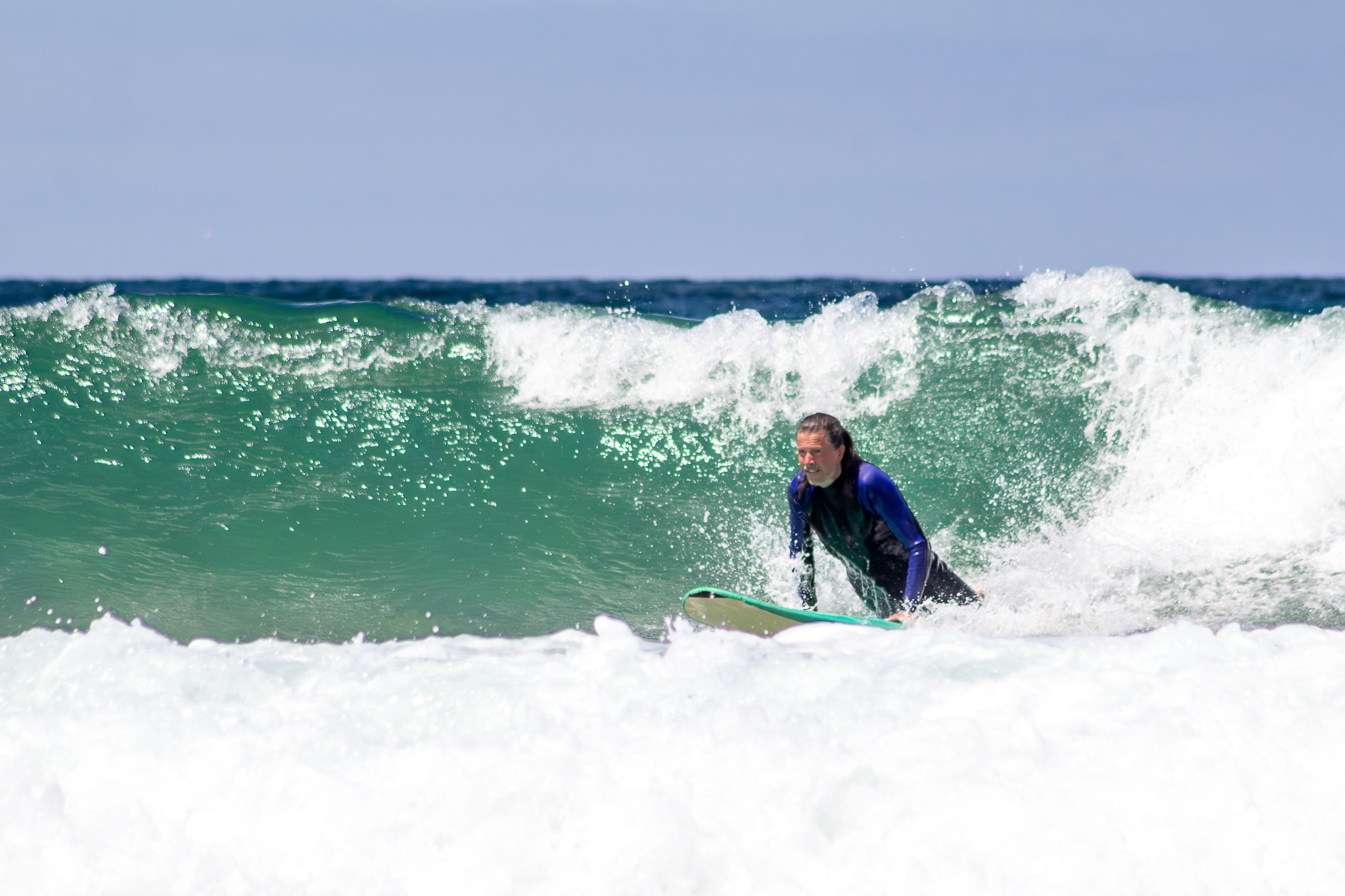 Action shot of a surfer riding a wave in the ocean, showcasing skill and excitement.