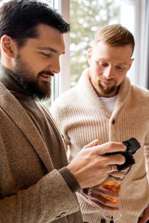 Man in Brown Coat Holding Black Camera