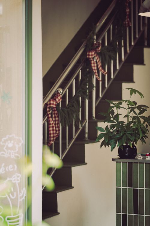 Free A charming indoor staircase decorated with checkered ribbons and greenery for the holidays. Stock Photo