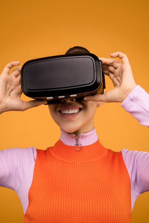 Woman in Long Sleeve Shirt Putting On Her VR Headset