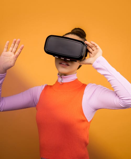 Woman in Long Sleeve Shirt Holding VR Headset