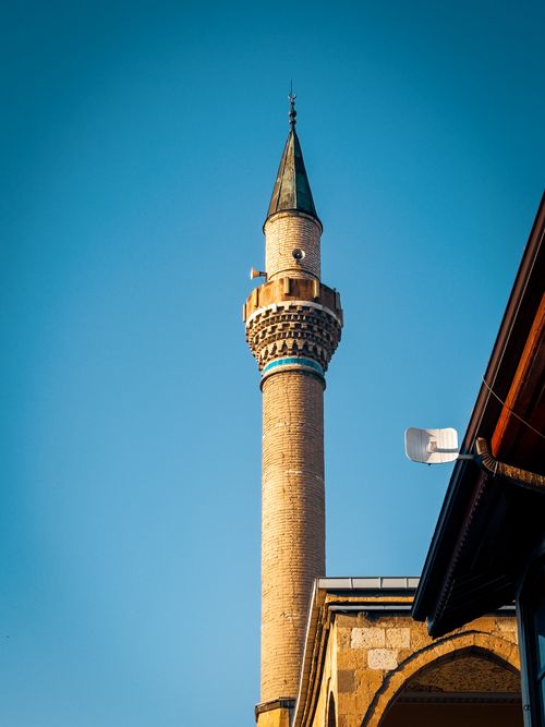 Free Stunning view of a traditional minaret tower reaching up into a bright blue sky, perfect for design projects. Stock Photo