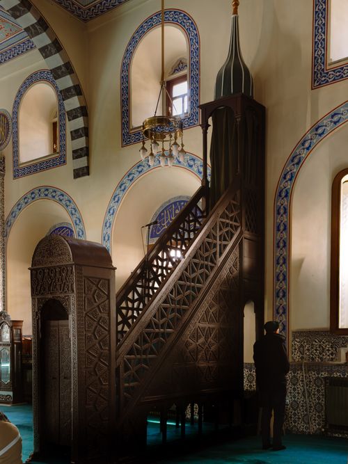 Free Detailed view of a mosque interior showcasing ornate architecture and Islamic art with a person standing. Stock Photo