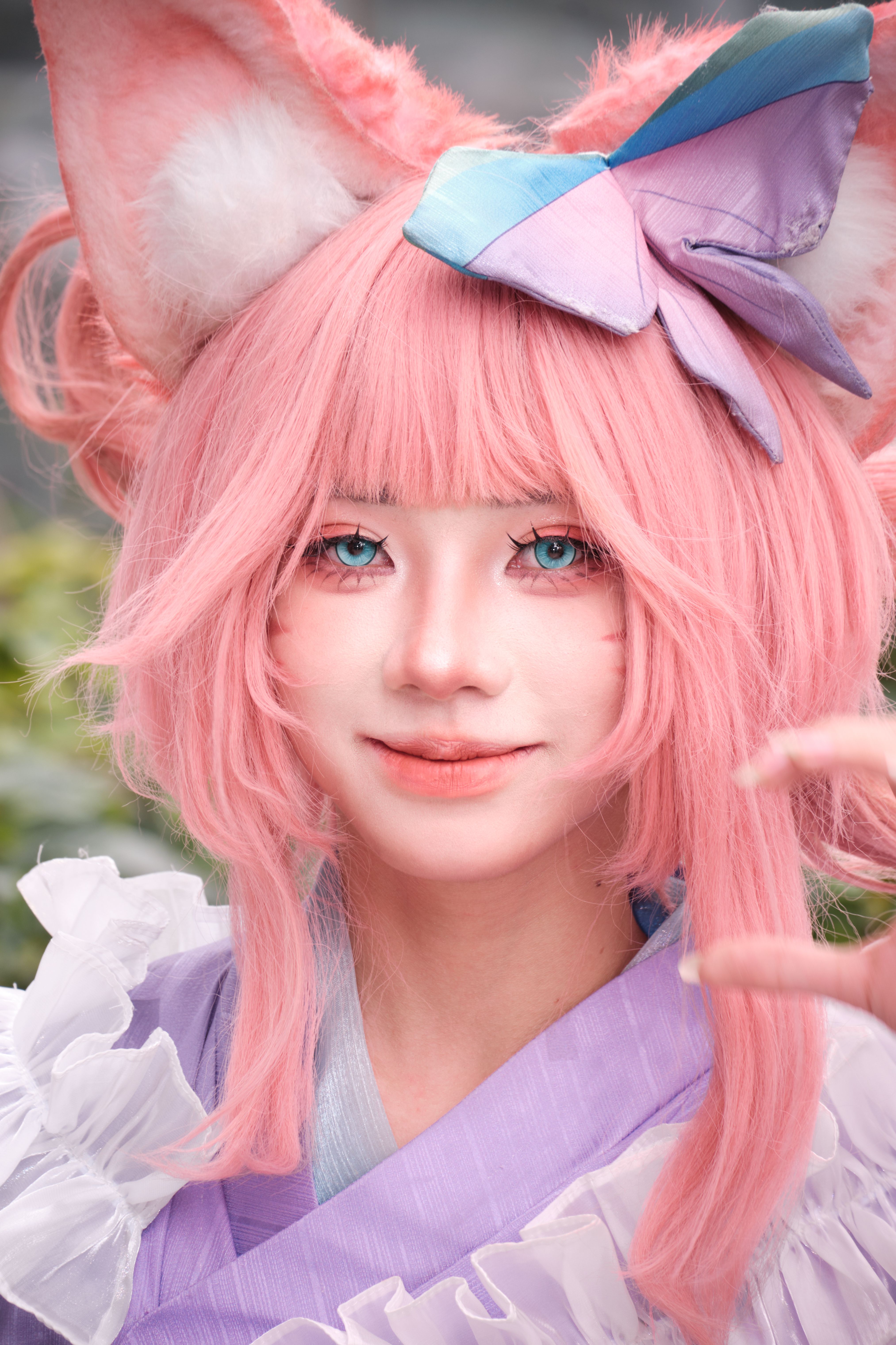 Vibrant cosplay portrait with pink wig, fox ears, and playful costume details.