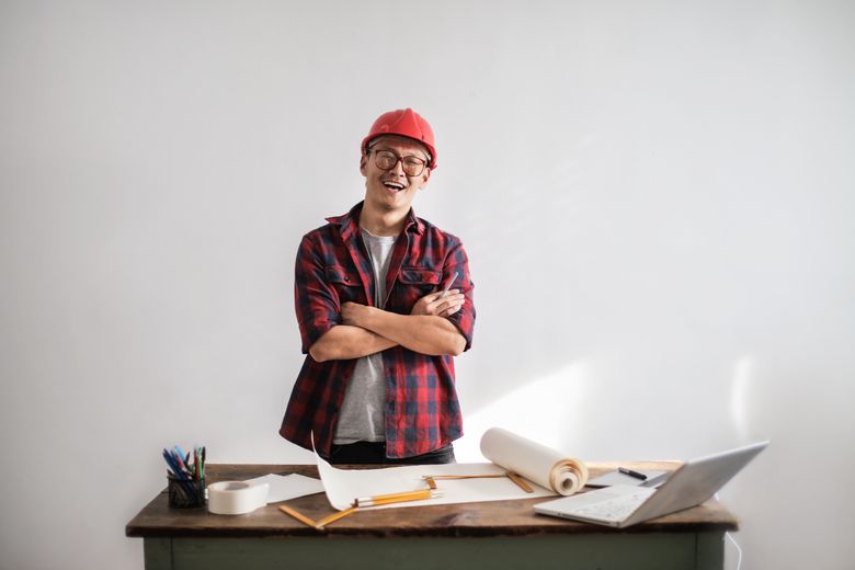 Smiling contractor in a hardhat with his arms crossed