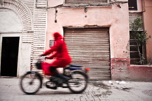 Woman in Red Coat Using Bicycle