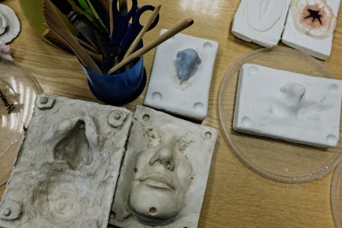 White Ceramic Face Figurine on Brown Wooden Table