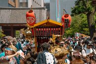 Vibrant festival scene in Tokyo with traditional mikoshi and crowd celebration.