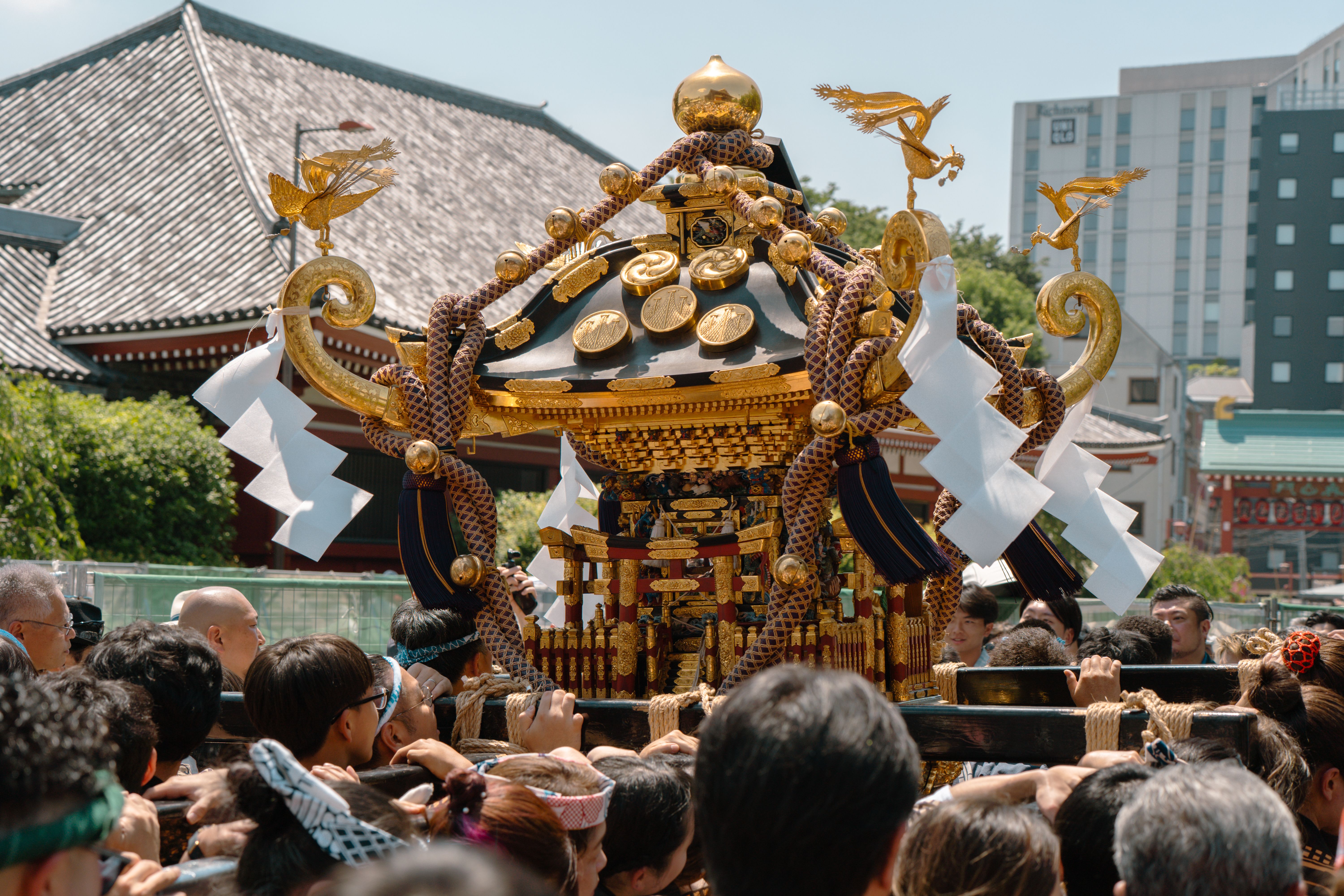 A vibrant festival procession with a mikoshi in Tokyo, Japan, showcasing cultural traditions.