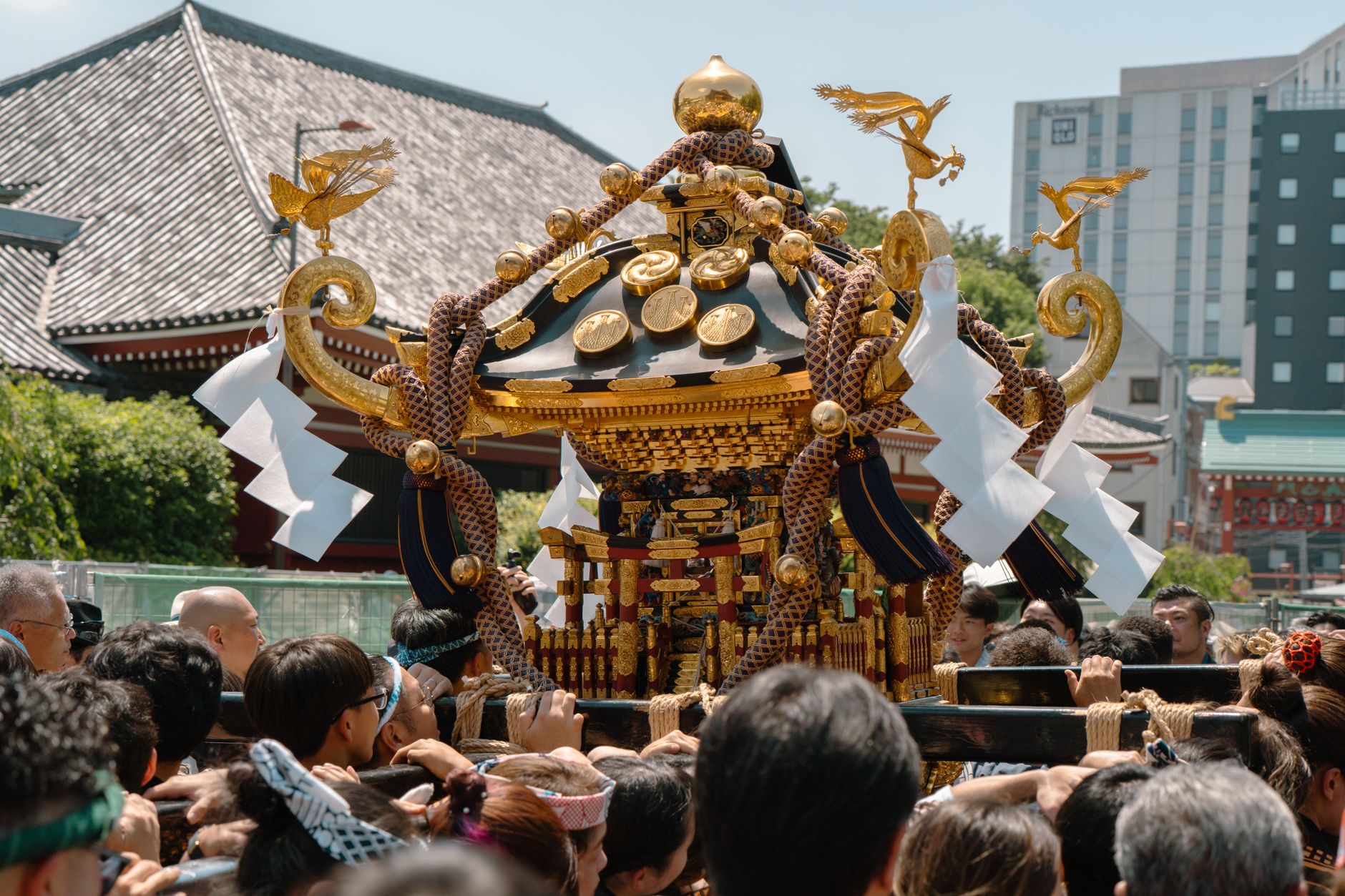A vibrant festival procession with a mikoshi in Tokyo, Japan, showcasing cultural traditions.