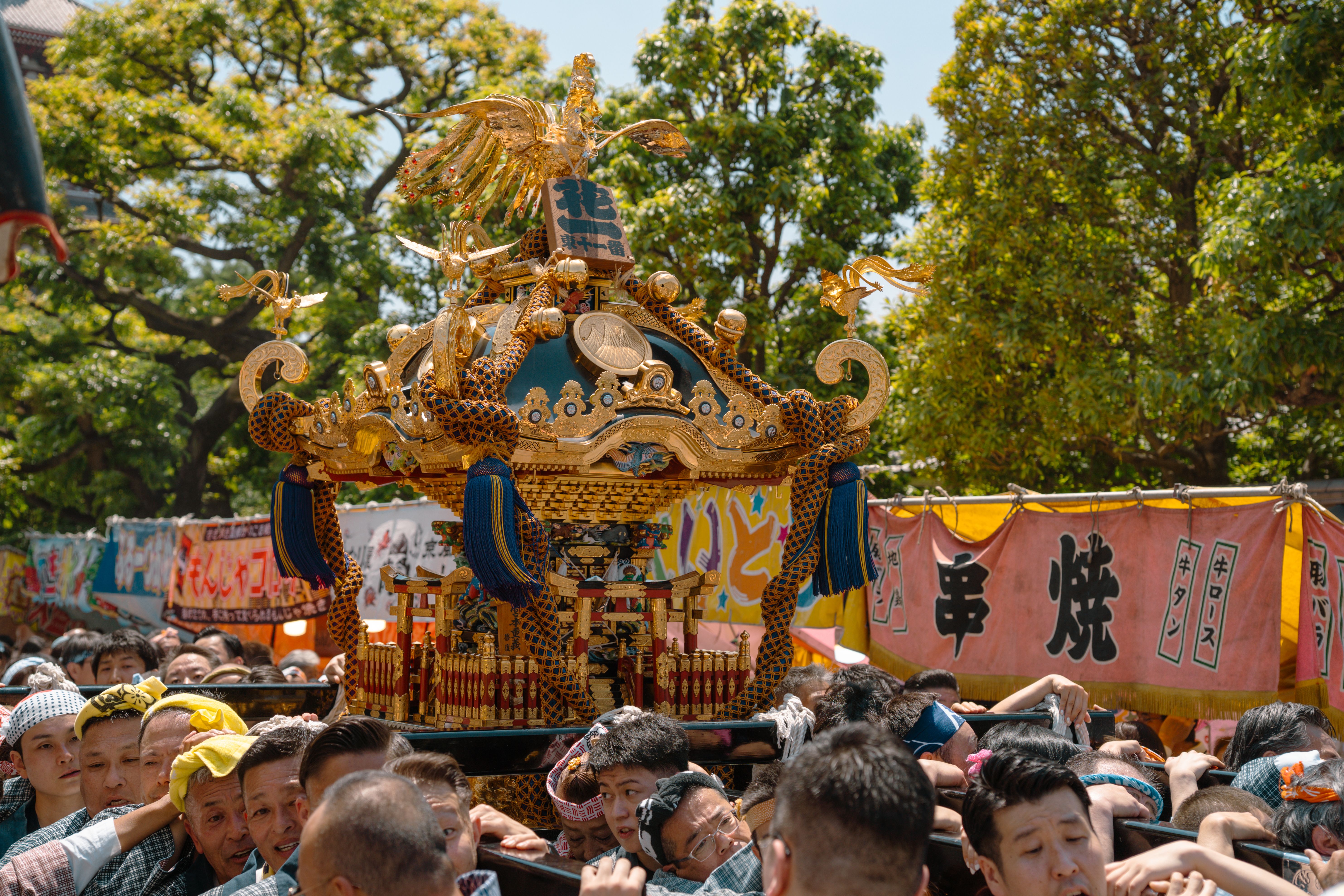 色鮮やかな旗と熱狂的な参加者で賑わう、日本の東京で行われた活気あふれる神輿行列。