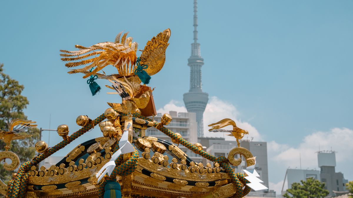 일본 골든위크 — Golden mikoshi with intricate decorations and Tokyo Skytree in the background on a clear day.