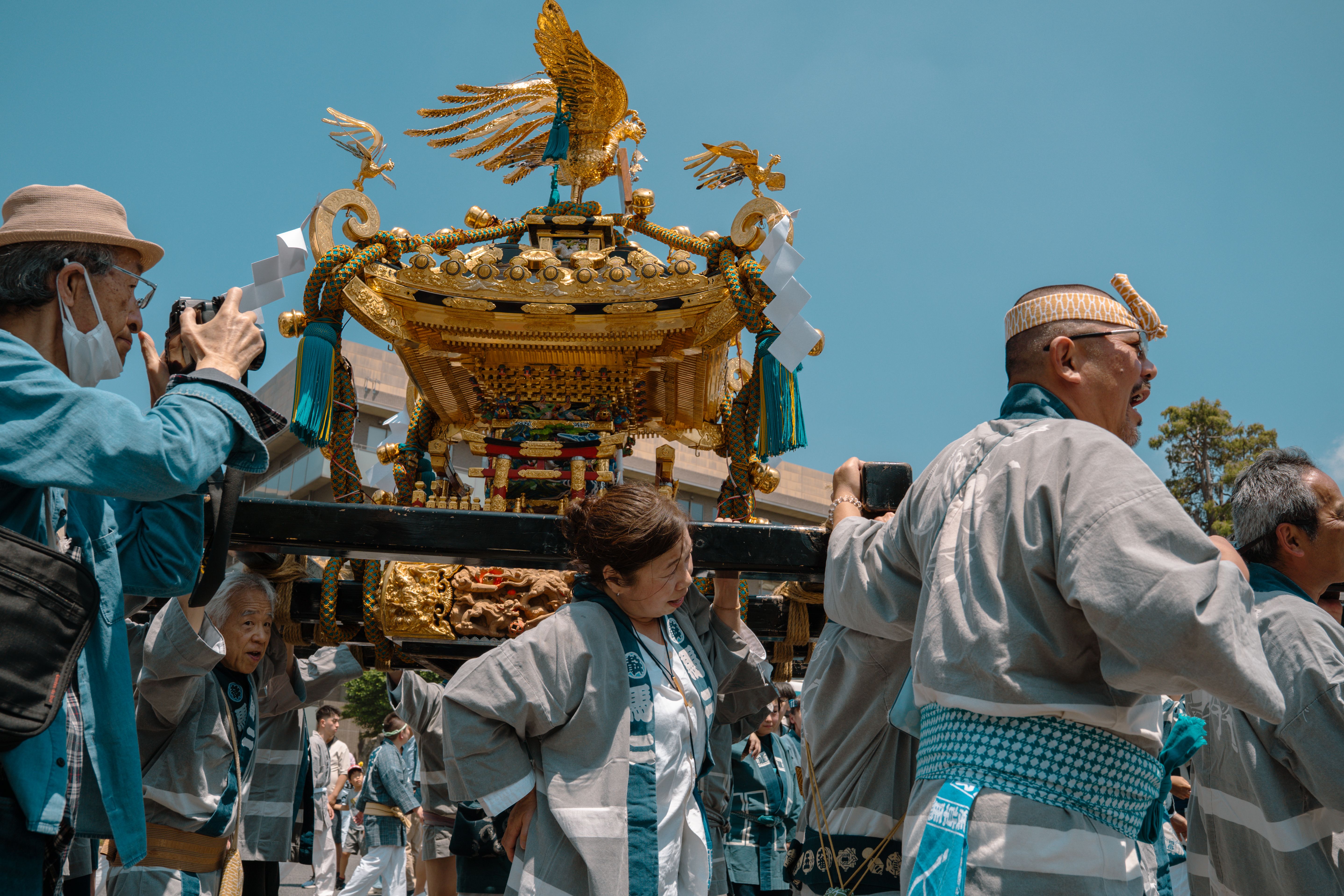A Mikoshi parade with participants in traditional attire during a festival in Tokyo, Japan.