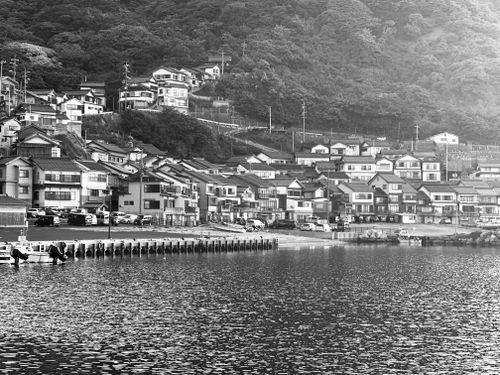 Free Picturesque view of a Japanese coastal village with traditional houses, captured in black and white. Stock Photo