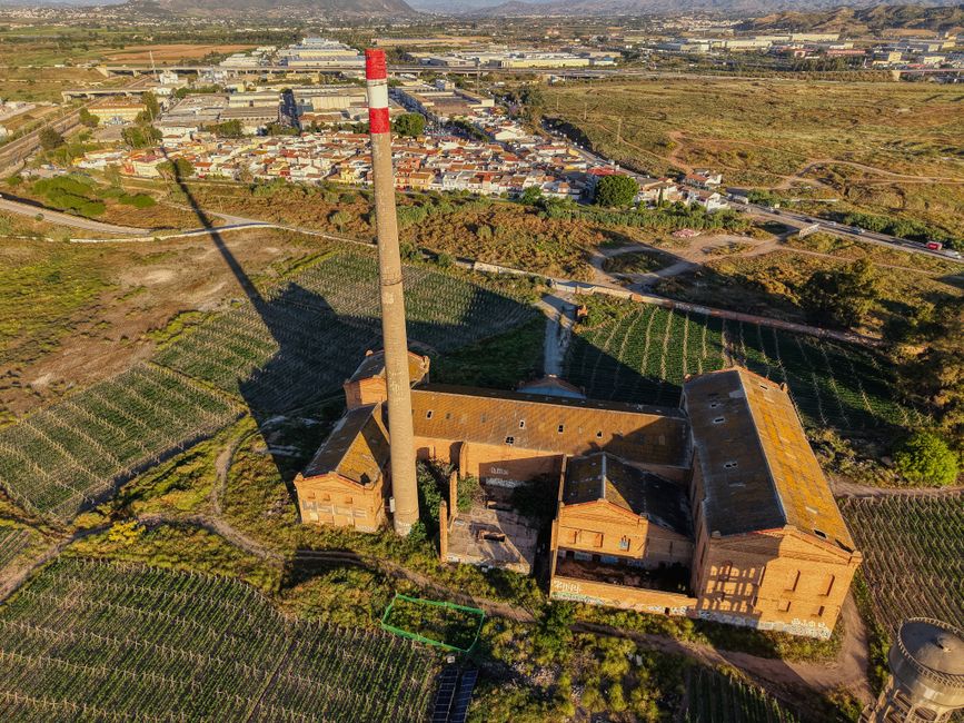 Aerial view highlighting a historic chimney and surrounding buildings in rural Málaga, Spain.