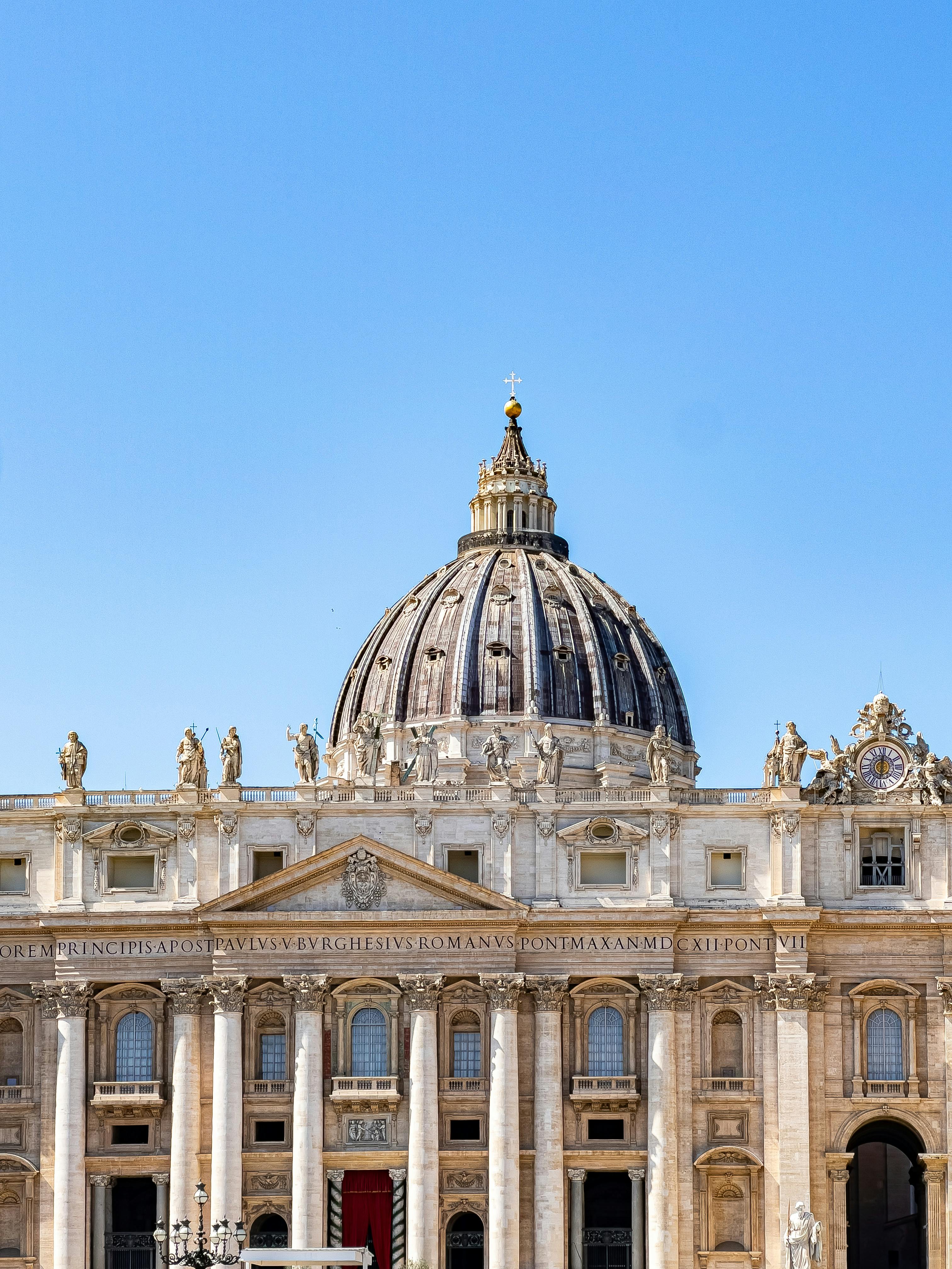 Stunning view of St. Peter's Basilica dome against a clear blue sky in Vatican City.