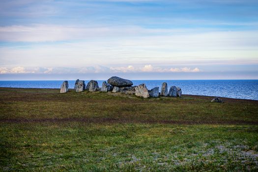Majestic stone circle on Swedish coast under a serene sky, near the Baltic Sea.