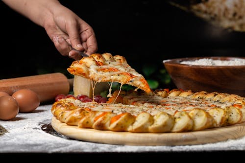 Persona Che Tiene La Pizza Sulla Tavola Di Legno