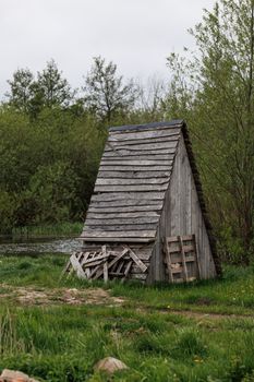 A rustic wooden cabin surrounded by lush green foliage in Kaliningrad, Russia.