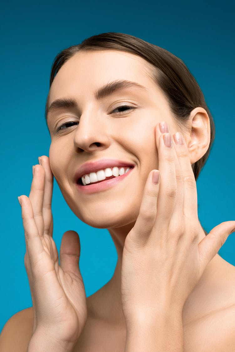 Smiling Woman With Both Hands On Her Face