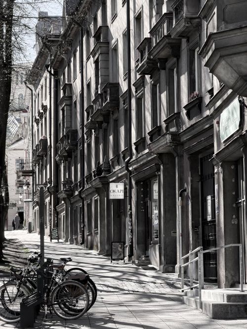 Free A scenic view of a historic street lined with classic architecture and bicycles, in soft light. Stock Photo