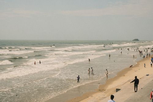 Free Beachgoers enjoy a sunny day along the shoreline in Ho Chi Minh City, Vietnam. Stock Photo