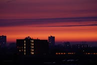 充满活力的日落天空映衬着令人惊叹的城市天际线轮廓，捕捉了从白天到夜晚的戏剧性转变