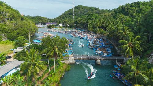 Free A picturesque aerial view of boats in a river amidst lush greenery in Jawa Timur, Indonesia. Stock Photo