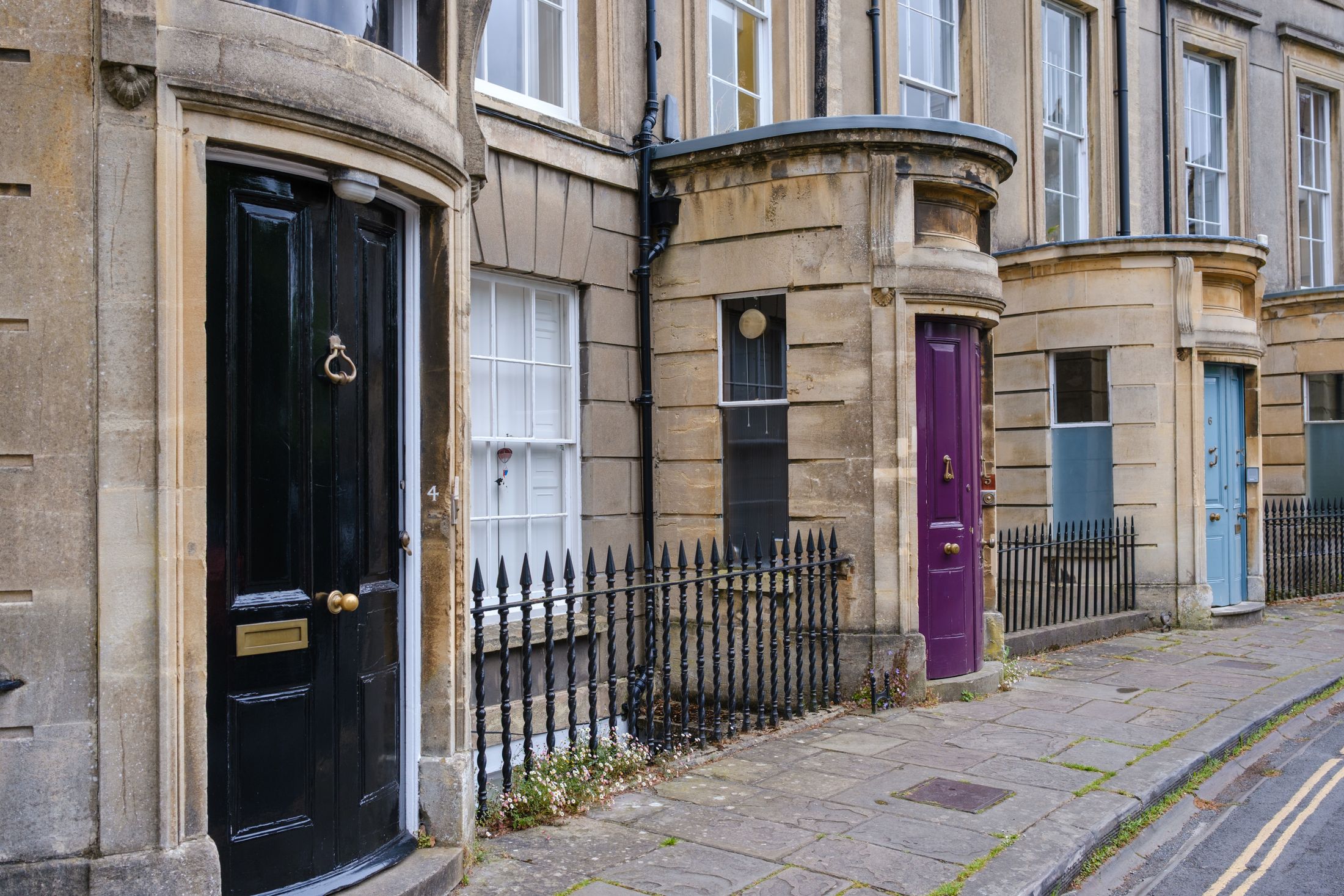 A row of vibrant Georgian-style front doors on a classic British street