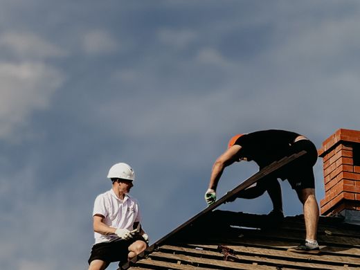 Due operatori al lavoro su una copertura con cielo sereno