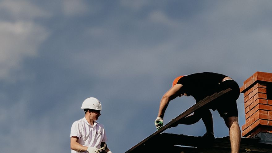 Due operatori al lavoro su una copertura con cielo sereno