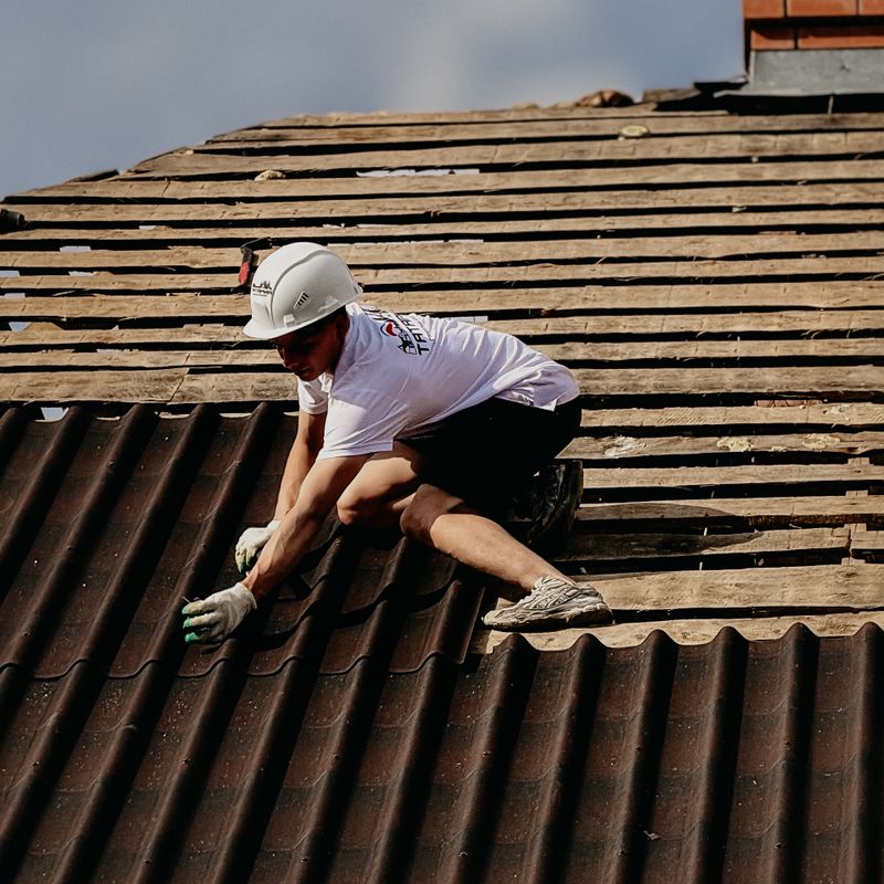 Roofer installing tiles on a sloped roof