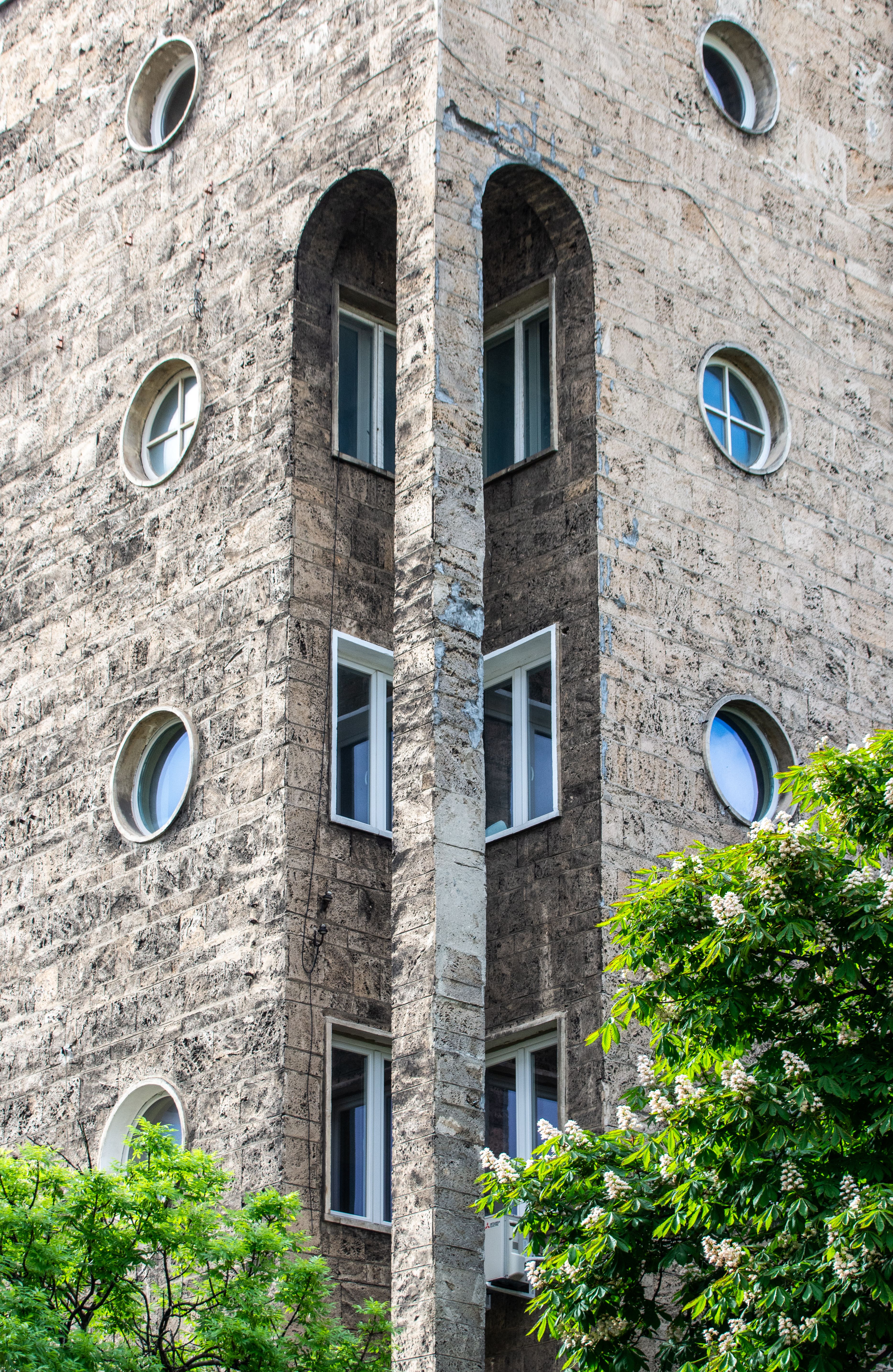 Modern Stone Building Corner with Round Windows · Free Stock Photo