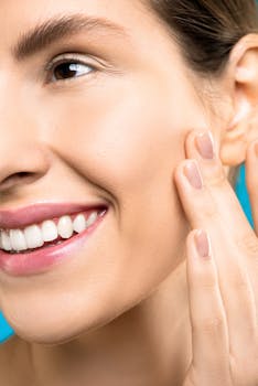 一张特写肖像中，一名女子轻触脸颊，展现出健康的肌肤和充满活力的微笑