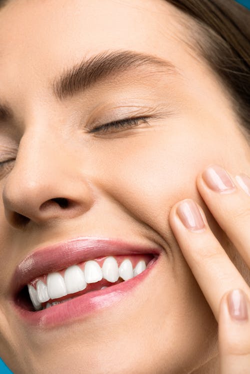 Foto Close Up Wanita Dengan Lipstik Merah Muda Tersenyum Dengan Mata Tertutup