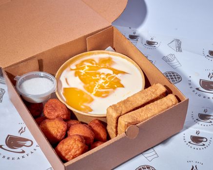 Tasty Nigerian breakfast box featuring yam, akara, egg sauce, and dipping salt.