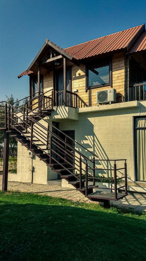 Free A beautiful two-story house with an external staircase under a clear blue sky. Stock Photo