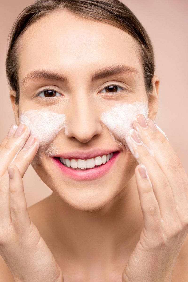 Woman gently washing face with foamy cleanser
