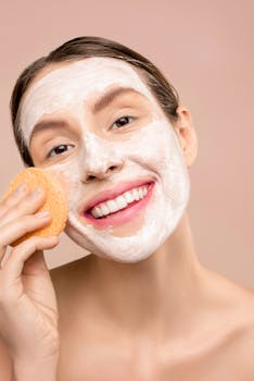 Woman enjoying skincare routine with facial foam and sponge. Bright uplifting image.