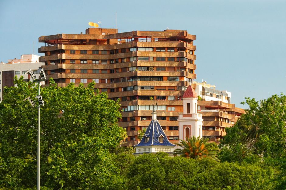 Una mezcla de arquitectura moderna y clásica rodeada de vegetación exuberante bajo un cielo despejado.