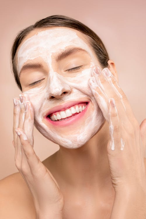無料 顔に白い顔の石鹸を持つ女性 写真素材