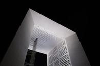 The iconic Grande Arche illuminated against the night sky in La Défense, Paris.