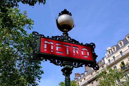 Free Elegant Paris metro sign with typical architecture and clear blue sky backdrop. Stock Photo