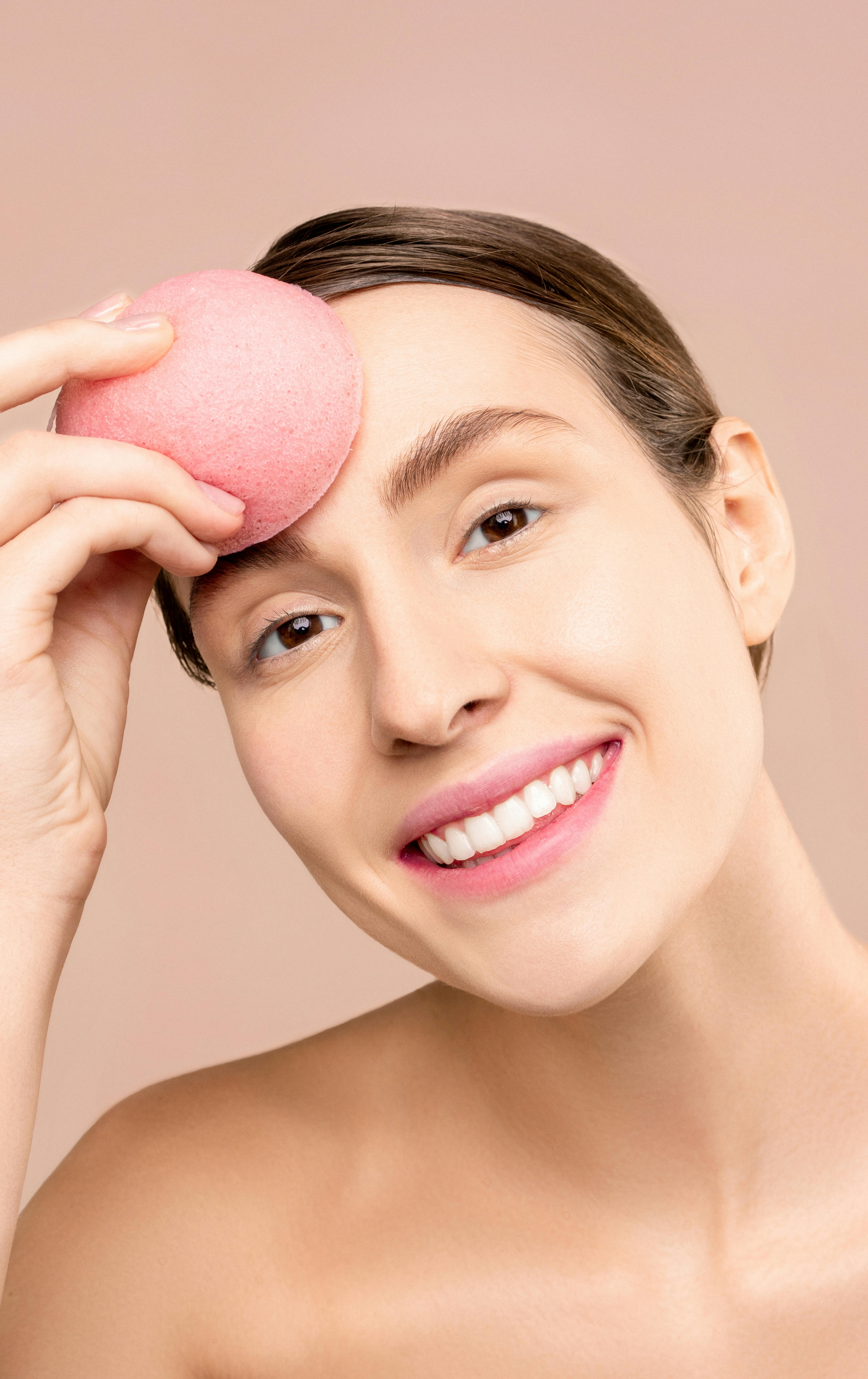 a woman using a makeup sponge blender