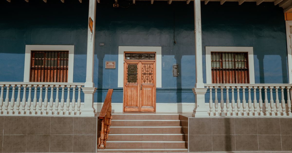 Charming home exterior with a wooden entry door in need of care