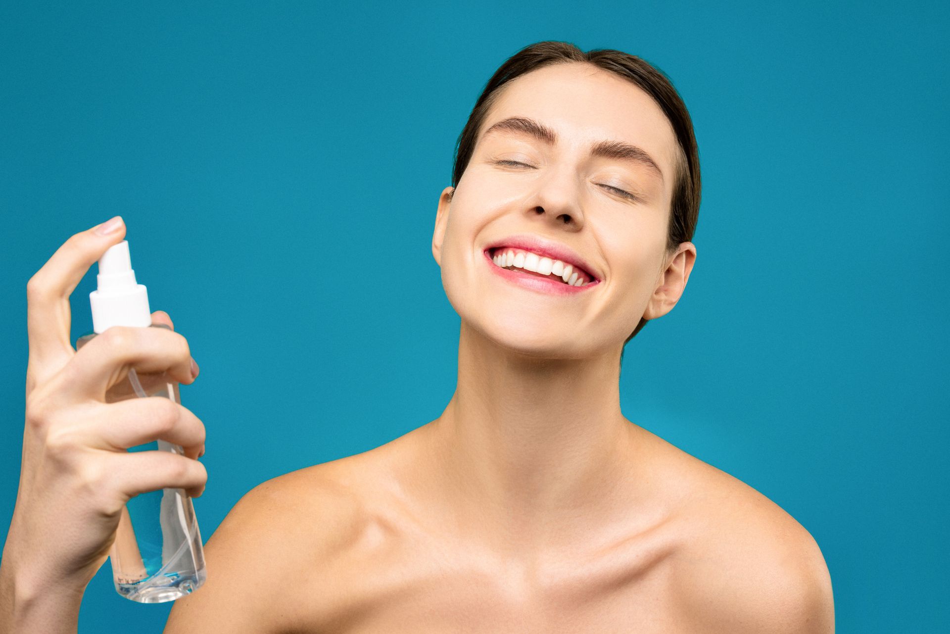 Smiling Woman Holding Clear Spray Bottle