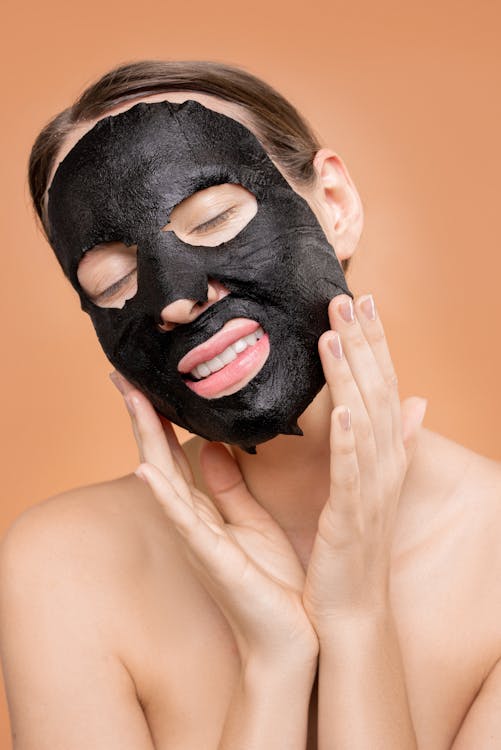 Free Topless Woman Covering Her Face With Black Mask Stock Photo